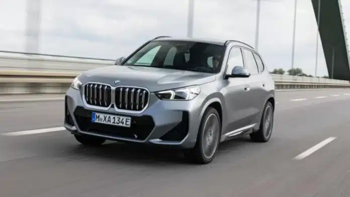 BMW iX1 being driven over a bridge during daytime